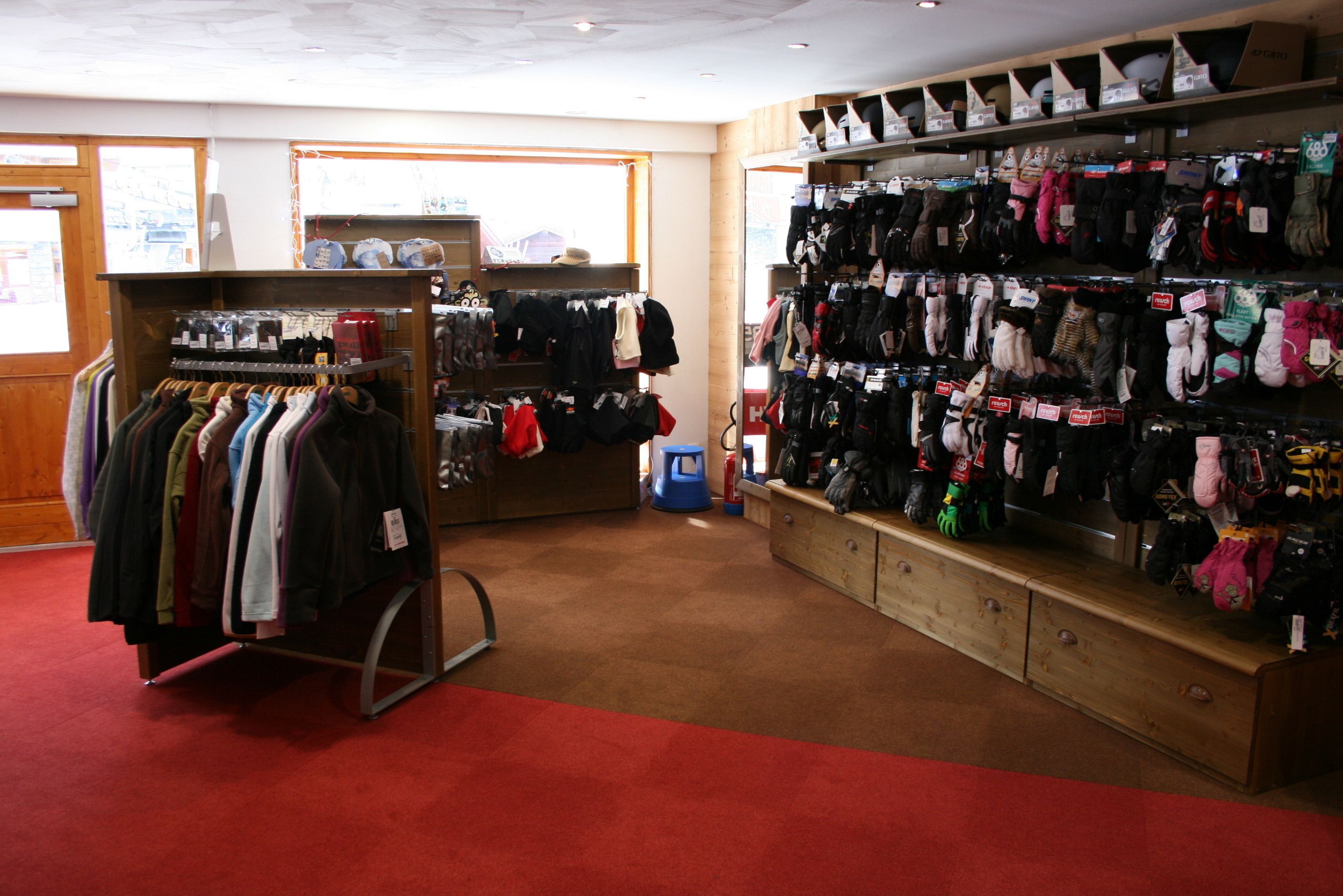 A clothing store with racks of clothes and shelves of hats.