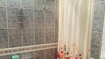 Ein Badezimmer mit Toilette, einer Duschvorhang und einem Handtuchhalter.