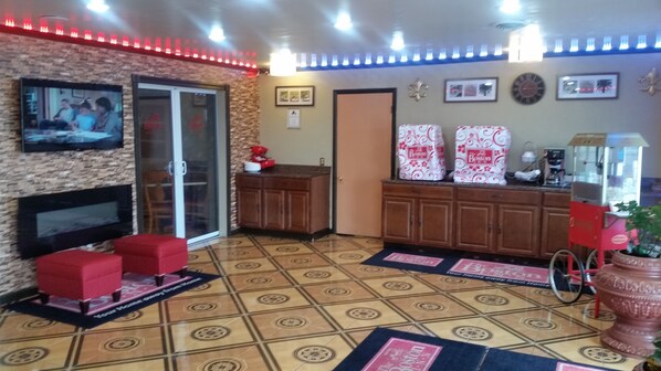 A living room with a fireplace, a television, and a coffee machine. - Boston Inn (Westminster)