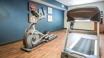 Un gimnasio con una máquina elíptica y una cinta de correr.