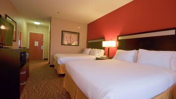 A hotel room with two beds, a desk, a lamp, and a framed picture on the wall.