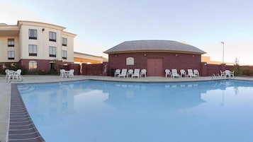 Una piscina al aire libre, sillones reclinables de piscina