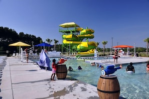 A water park with a pool, slides, and umbrellas.