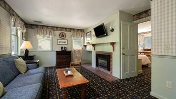 A living room with a sofa, a wooden table, a fireplace, and a television.
