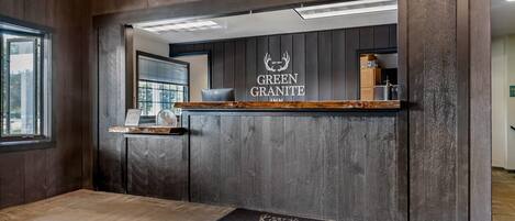 A reception area with a wooden wall, a reception desk, and a door.