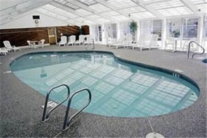 Una piscina techada, una piscina al aire libre de temporada, sombrillas