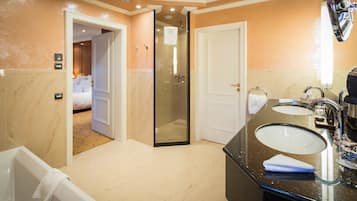 A modern bathroom with a bathtub, two sinks, and a walk-in shower.
