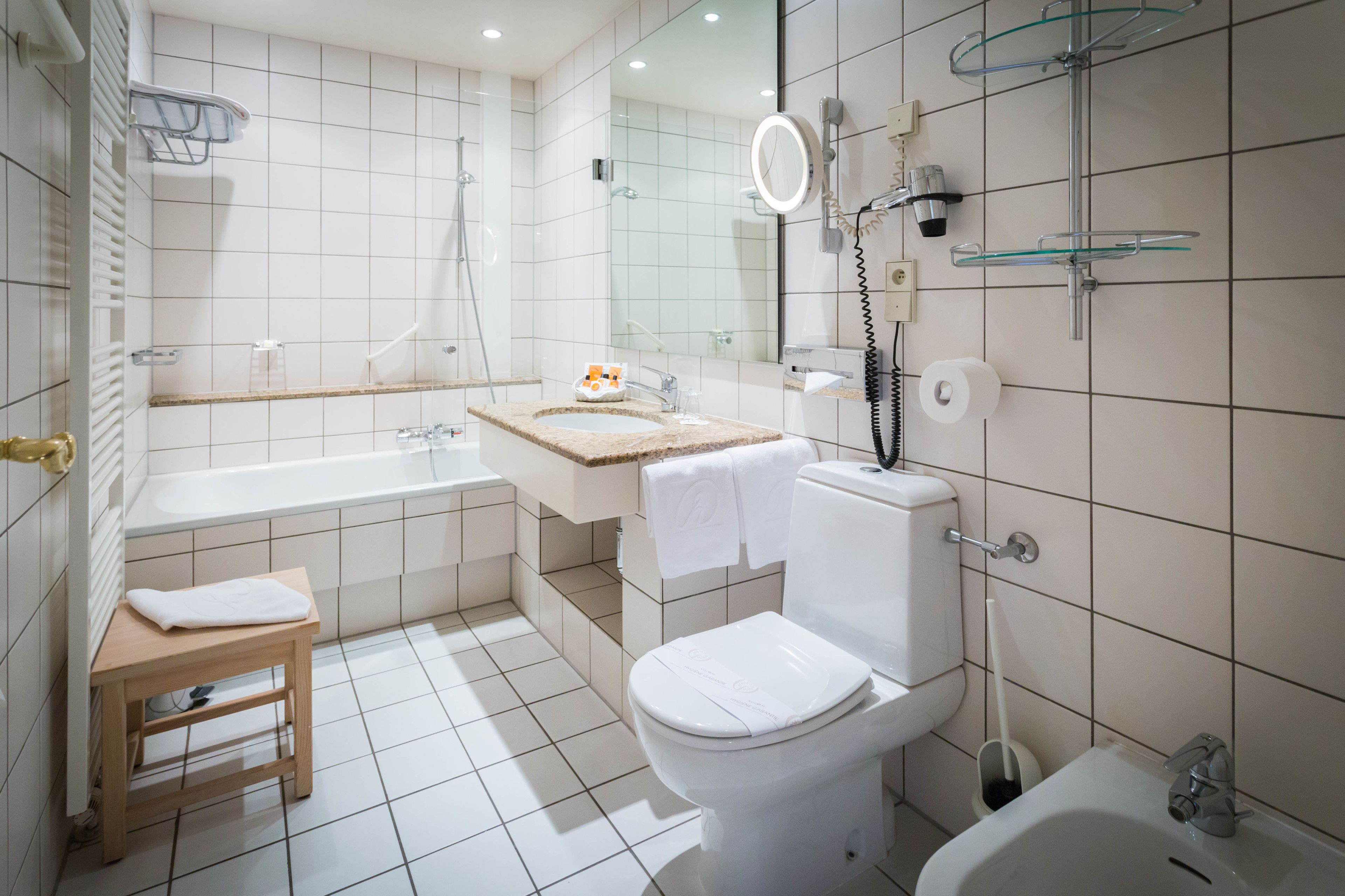Une salle de bain moderne équipée d’une baignoire, de toilettes et d’une douche.