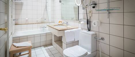 Une salle de bain moderne équipée d’une baignoire, de toilettes et d’une douche.