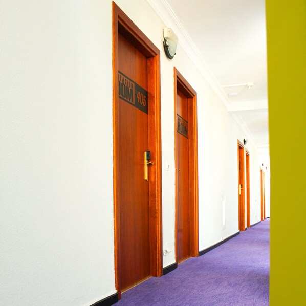 A hotel corridor with wooden doors, each marked with room numbers and a sign indicating a "Lobby Room." - Hotel Princesa Solar (Torremolinos)