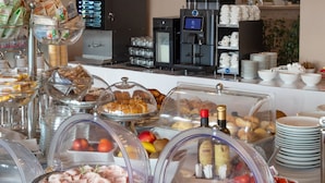 A buffet with various food items, including meats and pastries, in a hotel setting.