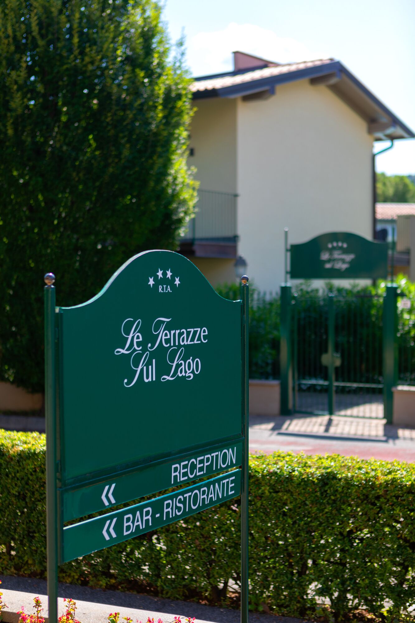 A sign for "Le Terrazze Giul Lago" with directions to the reception and bar/restaurants.