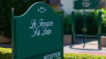 A sign for "Le Terrazze Giul Lago" with directions to the reception and bar/restaurants.