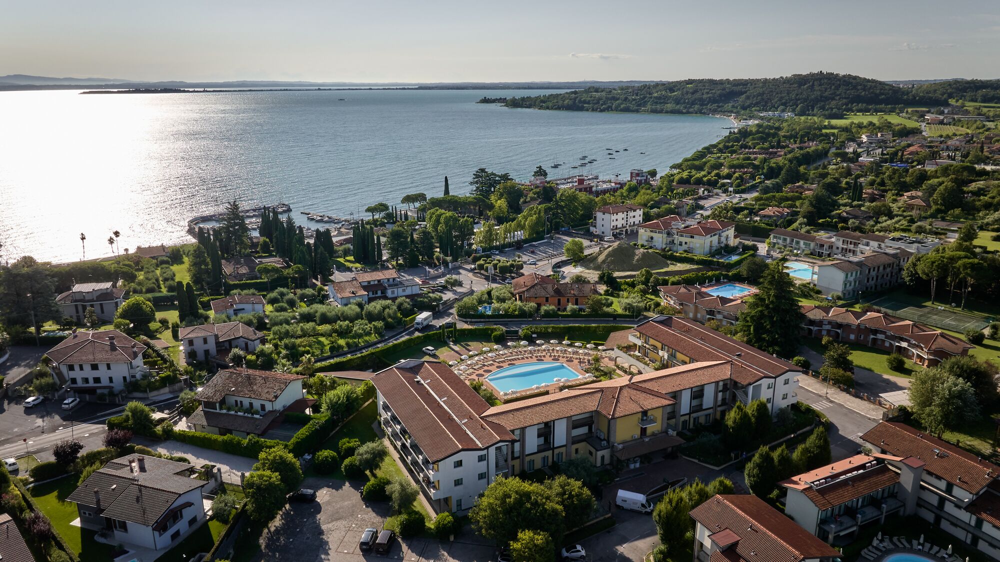 A coastal residential area with multiple buildings, a swimming pool, and a view of the sea.