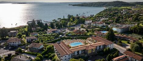 A coastal residential area with multiple buildings, a swimming pool, and a view of the sea.
