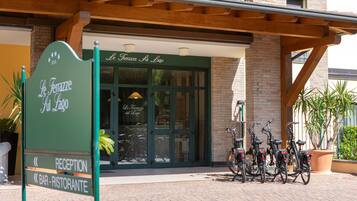 A building entrance with a sign reading "Le Terrazze sul Lago" and a reception area with bicycles parked outside.