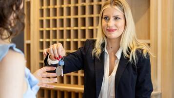 Una receptionist consegna le chiavi a un cliente.