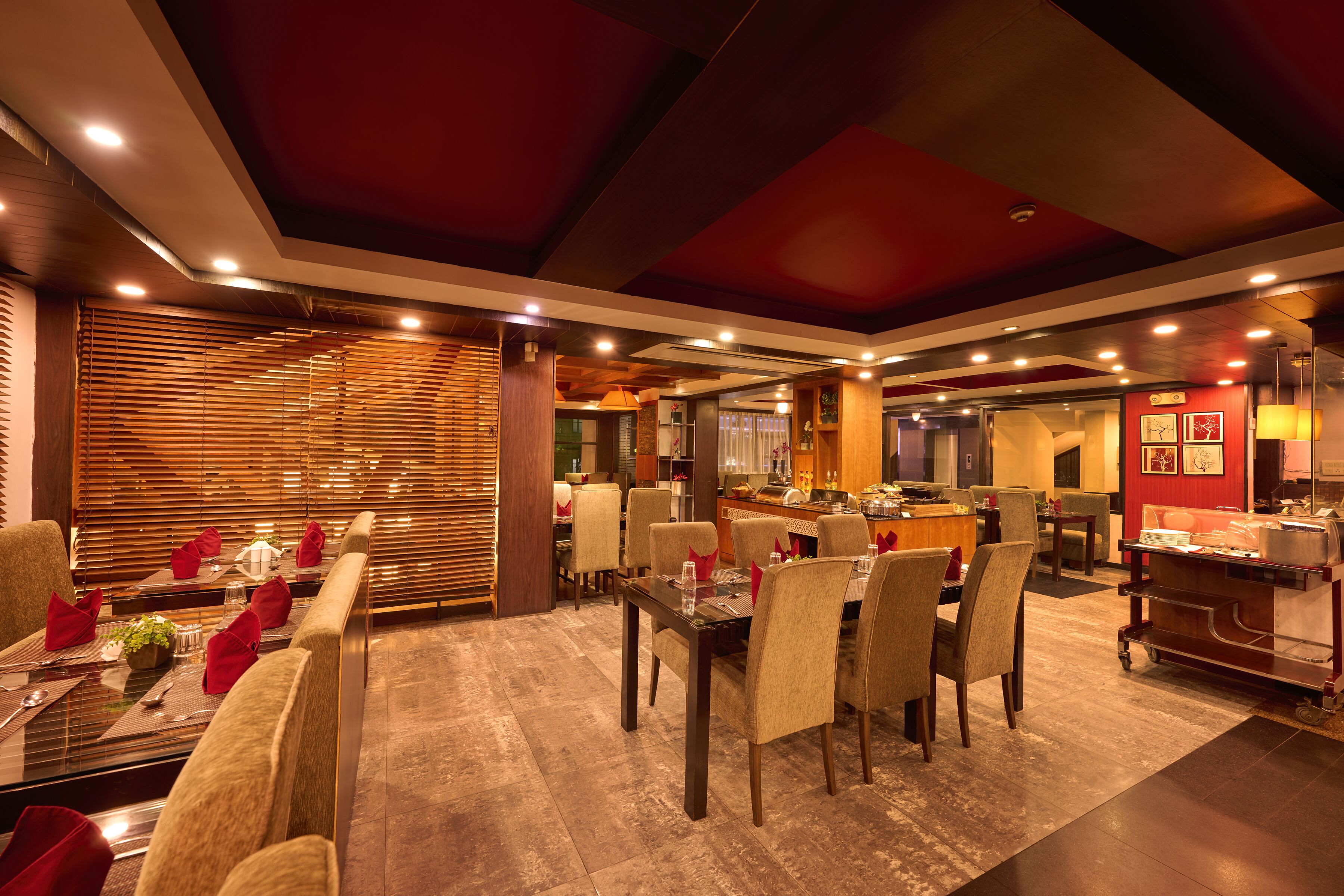 Un restaurante con una larga mesa de comedor, varias sillas y una zona de cocina al fondo.