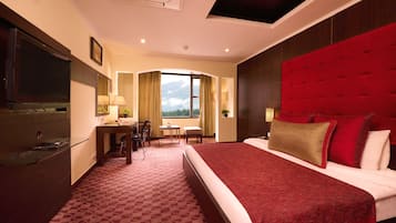 Una habitación de hotel con una cama grande, un escritorio, una silla y un televisor.