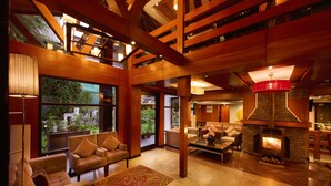 Un vestíbulo espacioso con chimenea, asientos cómodos y ventanas amplias que ofrecen vistas al exterior.