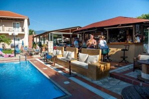 A poolside area with outdoor seating and a bar. - Sotiris Apartments (Kefalonia)