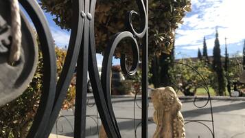 A wrought iron gate with a decorative lion statue in the background.