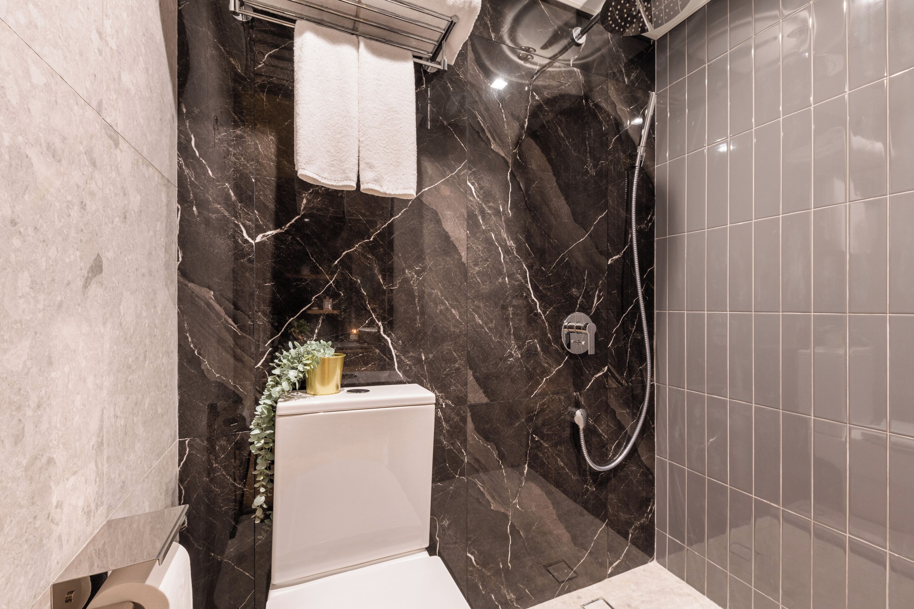 A bathroom with a toilet, a shower, and a sink.