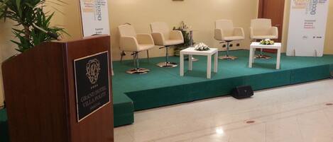A conference room with a podium, chairs, and a stage.