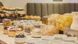 A buffet with various food items including cereals, fruits, and desserts.