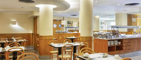 Un comedor de hotel con mesas y sillas, un bufé y un mostrador con alimentos.