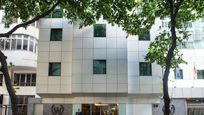 A modern building with a geometric facade, a glass entrance, and a bench outside. - Windsor Martinique Copacabana (Rio de Janeiro)