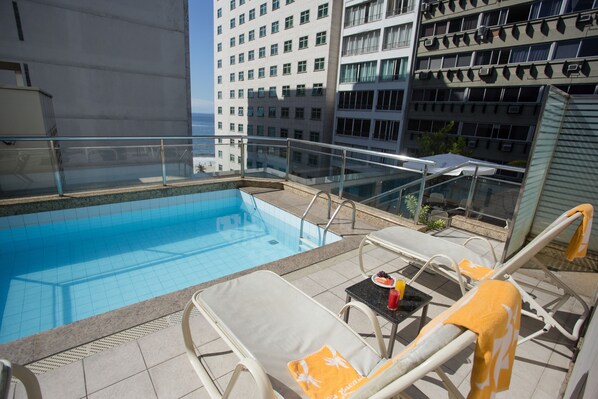 Una piscina al aire libre, sombrillas