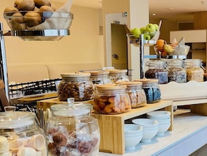 A buffet with various food items, including fruits, nuts, and other snacks.