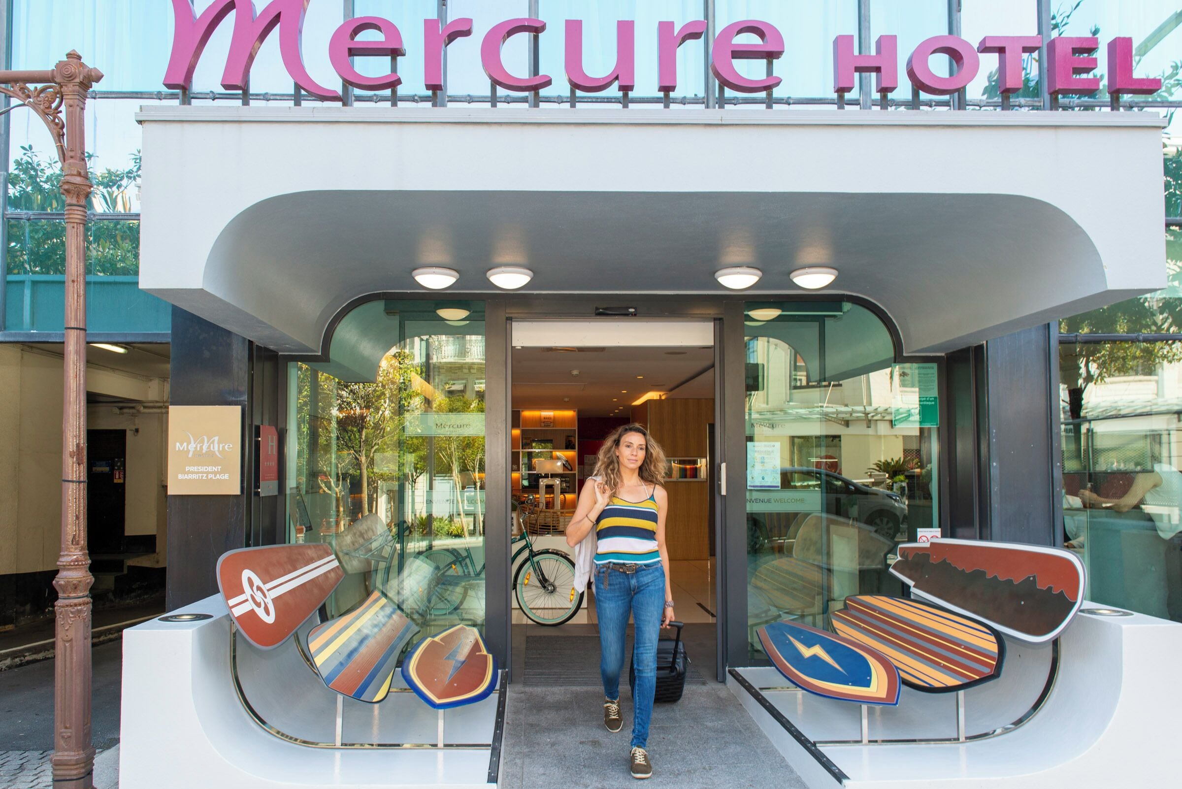 The exterior of Mercure Hotel with a modern design, including a glass entrance and a sign above the door.