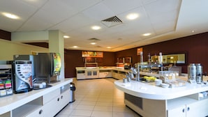 Un comptoir-bar moderne équipé d’une machine à café, d’un réfrigérateur et de divers produits alimentaires.