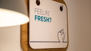 A sign with the text "FEELIN' FRESH?" and a drawing of an apple.