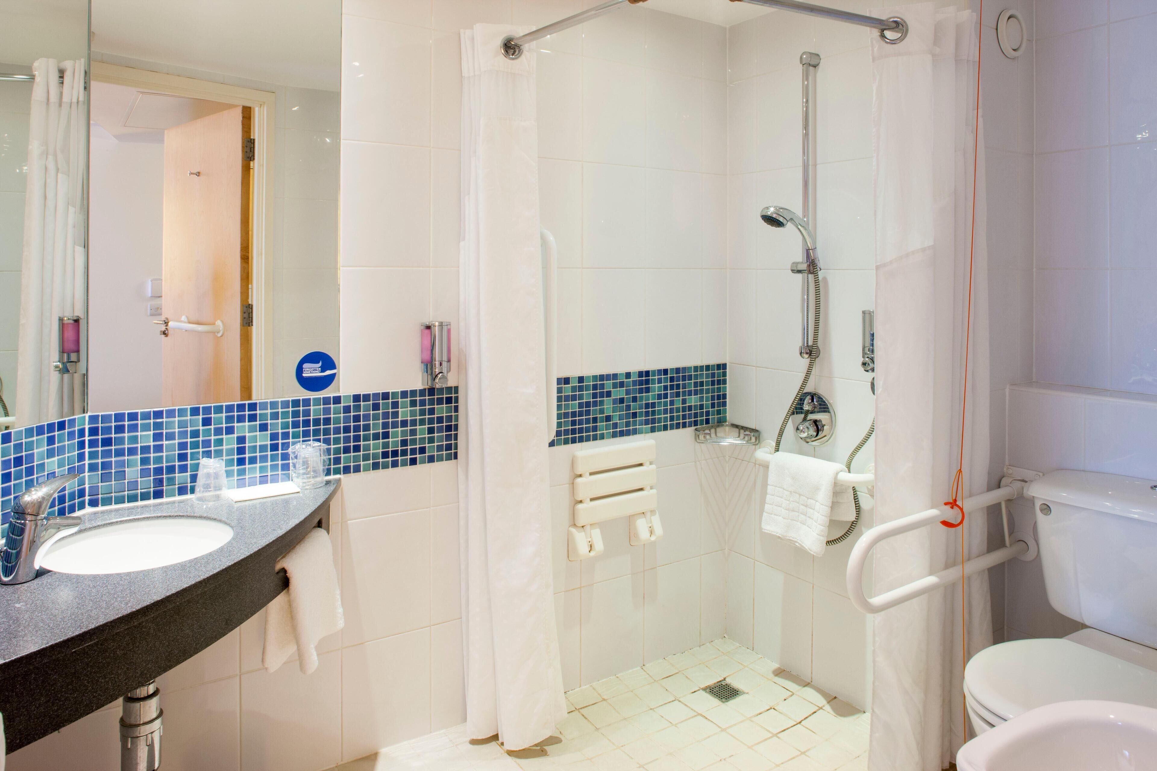 Badkamer | Een douche, een haardroger, handdoeken, zeep