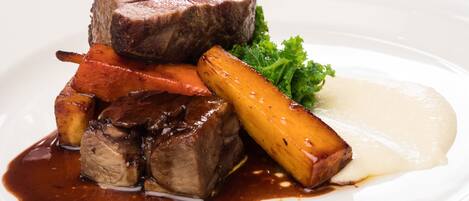 A plate of food with steak, carrots, and potatoes.
