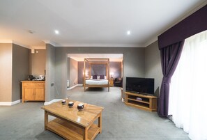 A hotel room with a bed, a TV, a wooden table, and a cabinet. - The Everglades Park Hotel (Widnes)