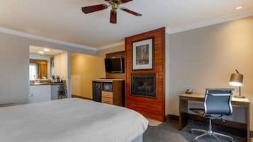 Una habitación de hotel con una cama grande, un escritorio con silla, televisor, microondas y un panel decorativo de madera.