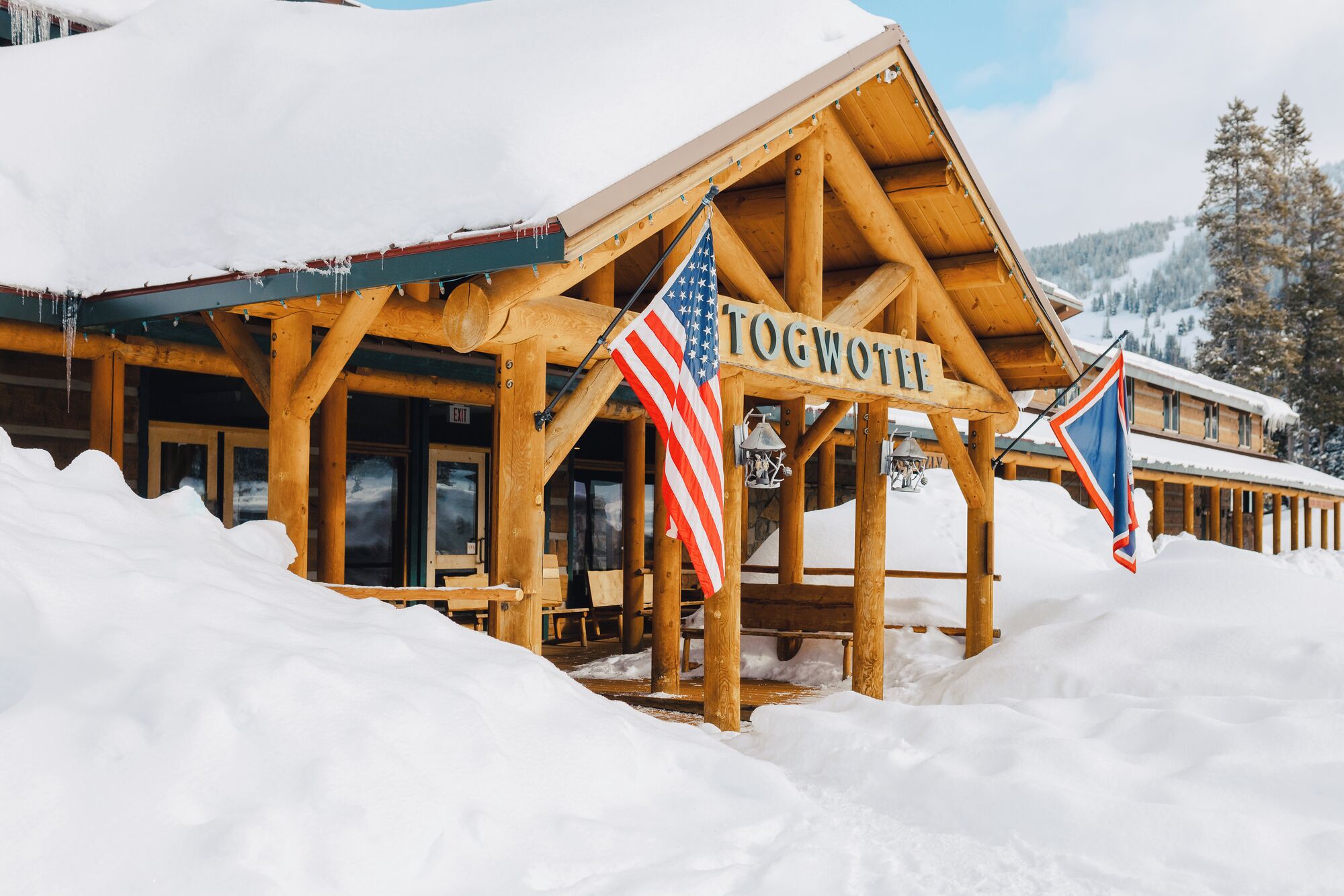 Un chalet en bois doté d’un porche et d’une enseigne sur laquelle on peut lire « TOGWOT ».