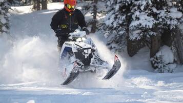 A person riding a snowmobile on a snowy path.