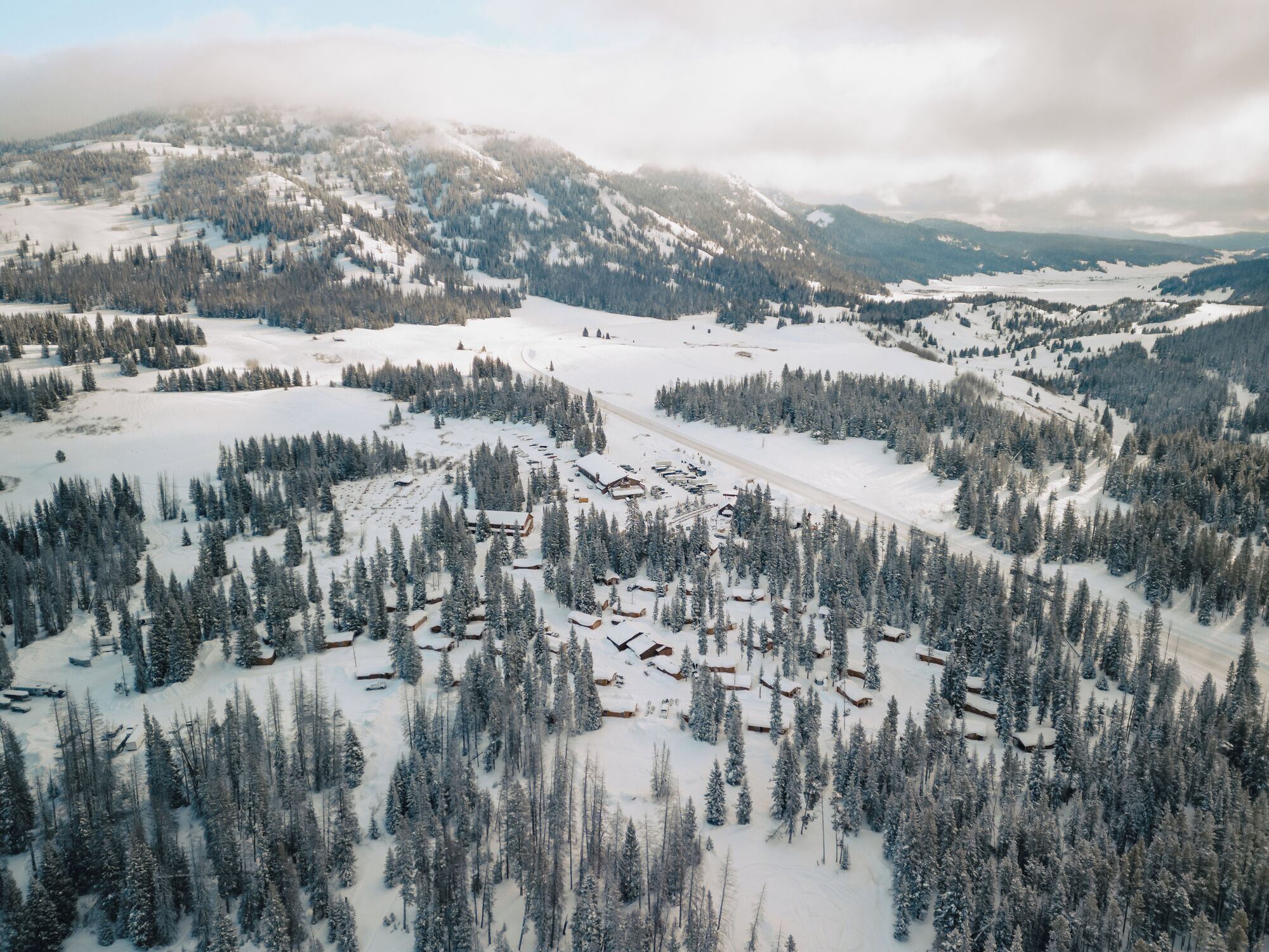Un paisaje montañoso cubierto de nieve con varias cabañas y una estación de esquí.