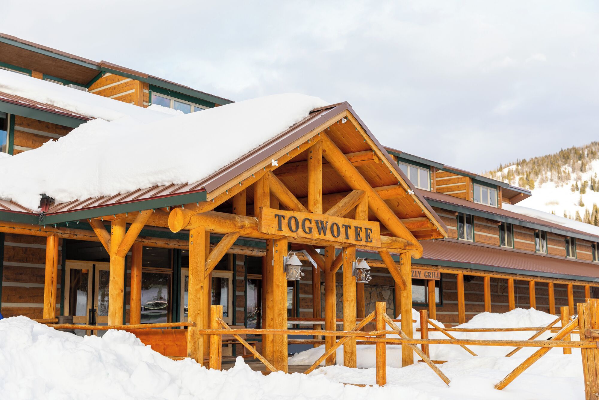 A wooden lodge with a sign reading "TOGWOTEE" and a "ZLY GRILL" sign.
