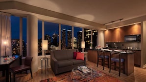 Un salon moderne avec un canapé, une table basse et une vue sur la ville.