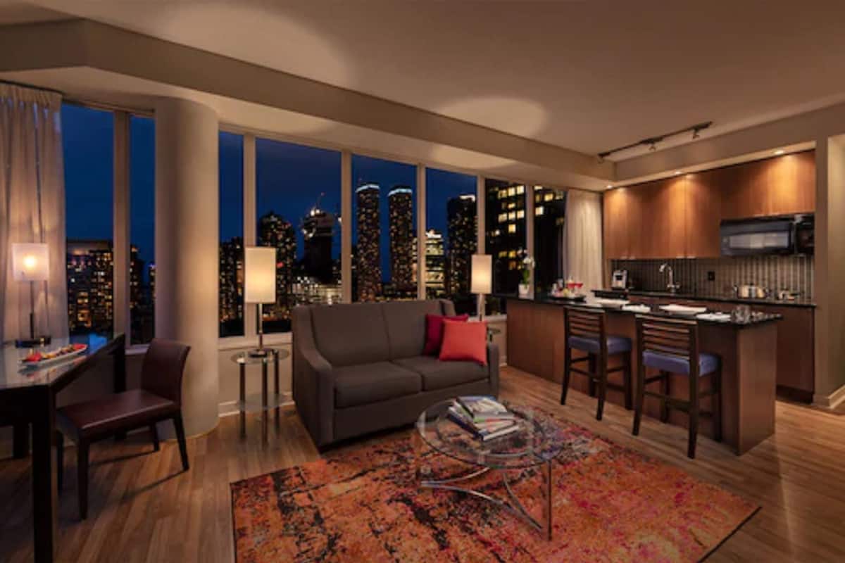 Ein modernes Wohnzimmer mit einer Couch, einem Couchtisch und Blick auf die Stadt.