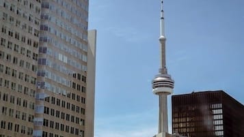 Un edificio de gran altura con una estructura de torre destacada, probablemente un punto de referencia, y edificios modernos adyacentes.