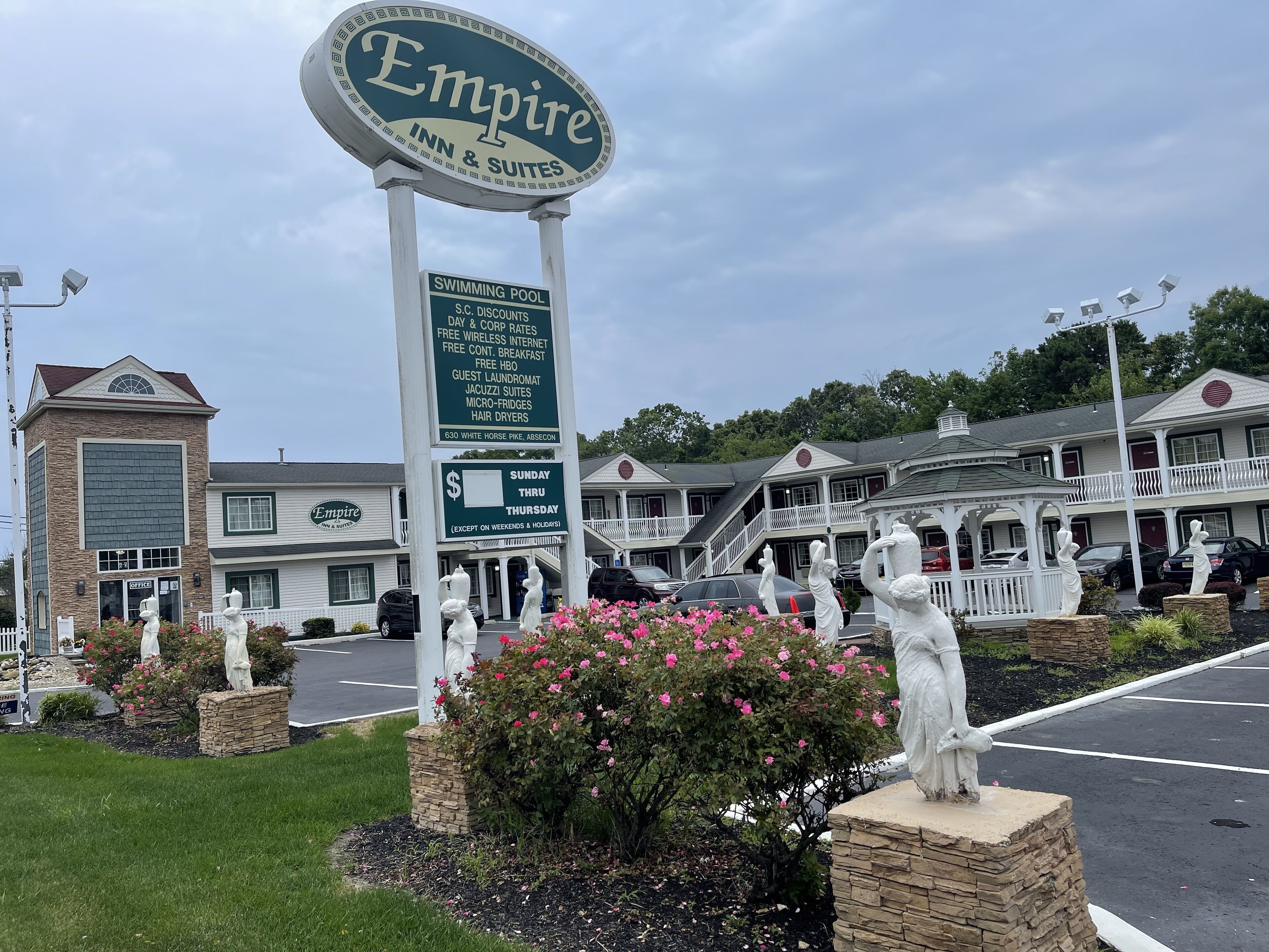 A hotel sign with amenities listed, including a swimming pool, guest laundry, and Jacuzzi suites.