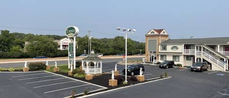 A parking lot with a gazebo, a sign for 'Empire Inn & Suites', and a building with a balcony.