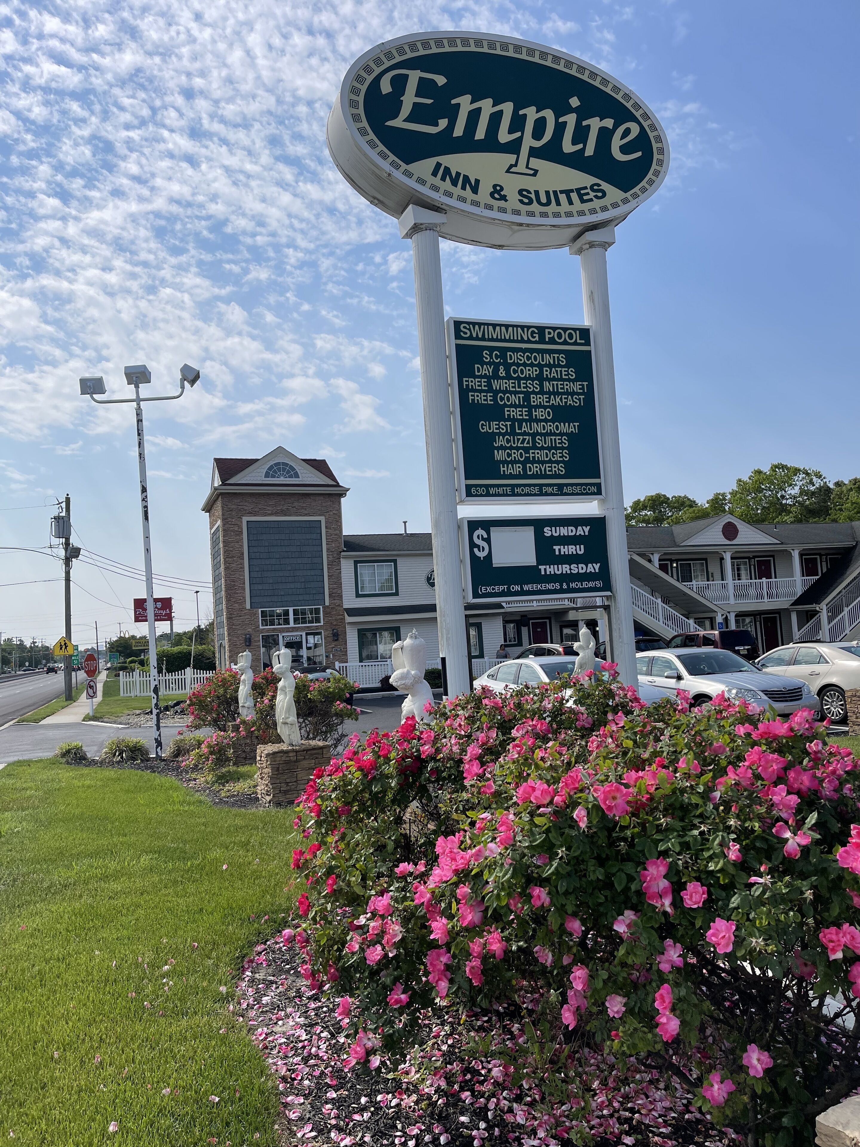 A hotel sign with amenities like a swimming pool, guest laundry, and free breakfast.